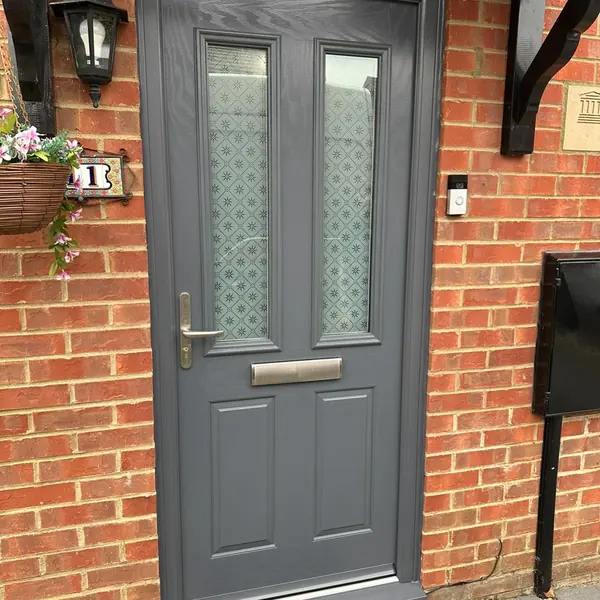 Grey composite front door with decorative glazing