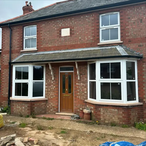 Detached house front with new white uPVC bay windows