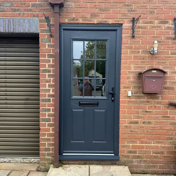 Anthracite composite door with a glazed top panel beside a garage