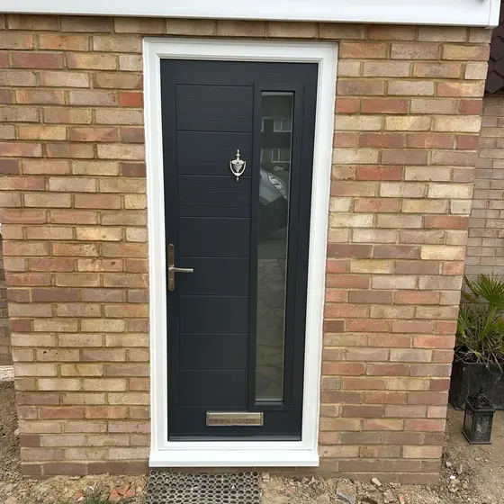 Anthracite composite door with a narrow glazed strip in a brick porch