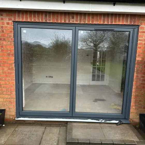 Anthracite grey sliding patio door opening onto a paved patio