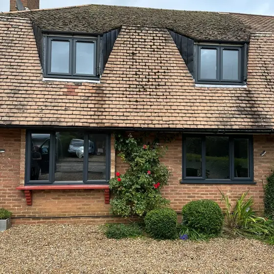 Cottage with anthracite grey windows in its dormers and ground floor