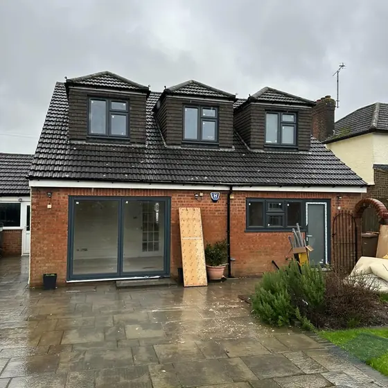 Dormer house with anthracite windows and patio doors to a new patio