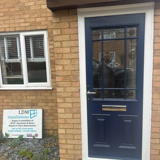 Navy composite front door with Georgian bar glazing and an LDM Installations sign