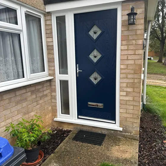 Navy composite door with diamond glazing in a white porch frame
