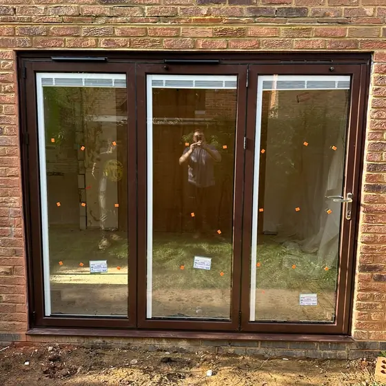 Rosewood-finish three-pane patio doors fitted into a new brick opening