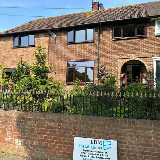 Row of brick terraced homes with new windows and an LDM Installations sign