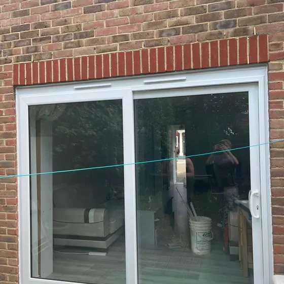 White sliding patio door in a brick house with a soldier course above