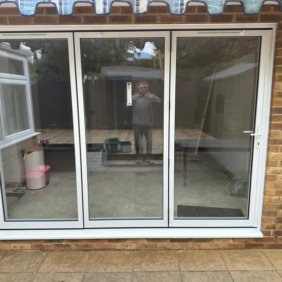 White three-pane patio doors opening onto a garden