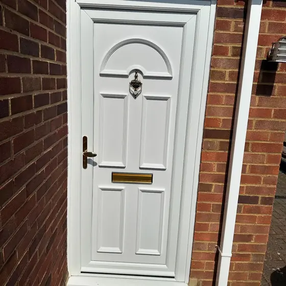 White uPVC panelled front door with a fanlight design and brass letterplate