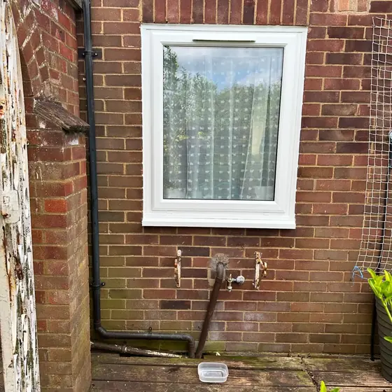 White uPVC window fitted in a red brick wall