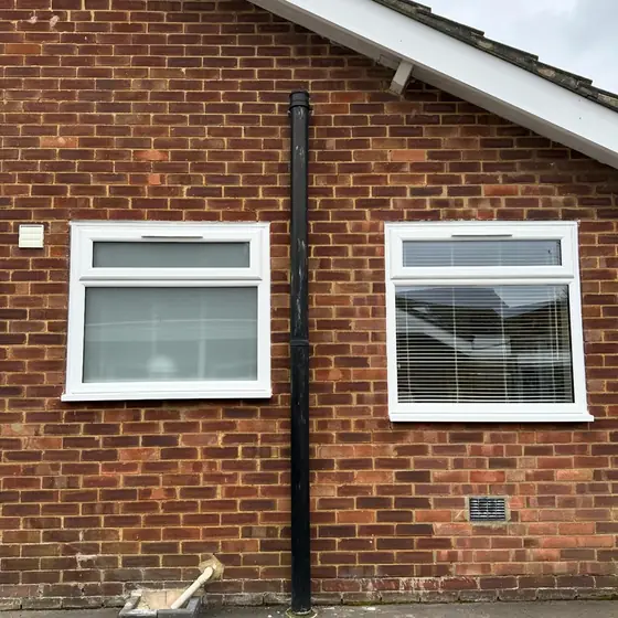 Two white uPVC casement windows on a single-storey brick extension