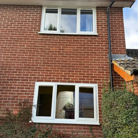 End-terrace brick house with new white windows on both floors