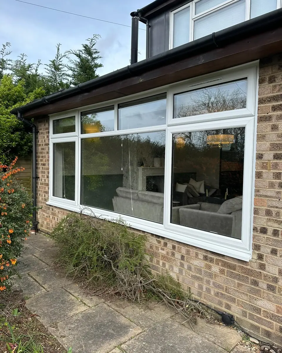 Long run of white windows across a garden room extension