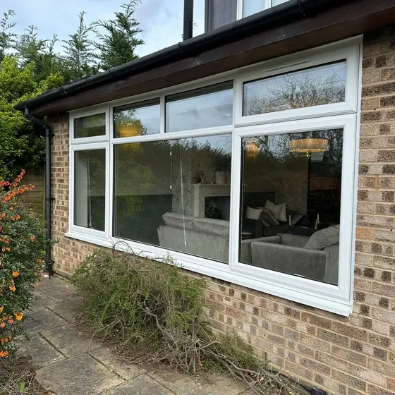Long run of white windows across a garden room extension